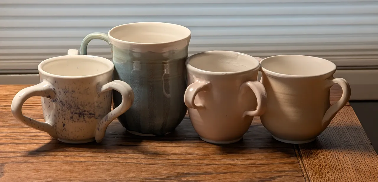 Yeah, so here’s some mugs. Overall., I’m getting okay at throwing mug bodies (the same tulip shape) but my handles are still lousy. There are fundamental flaws in each of these.