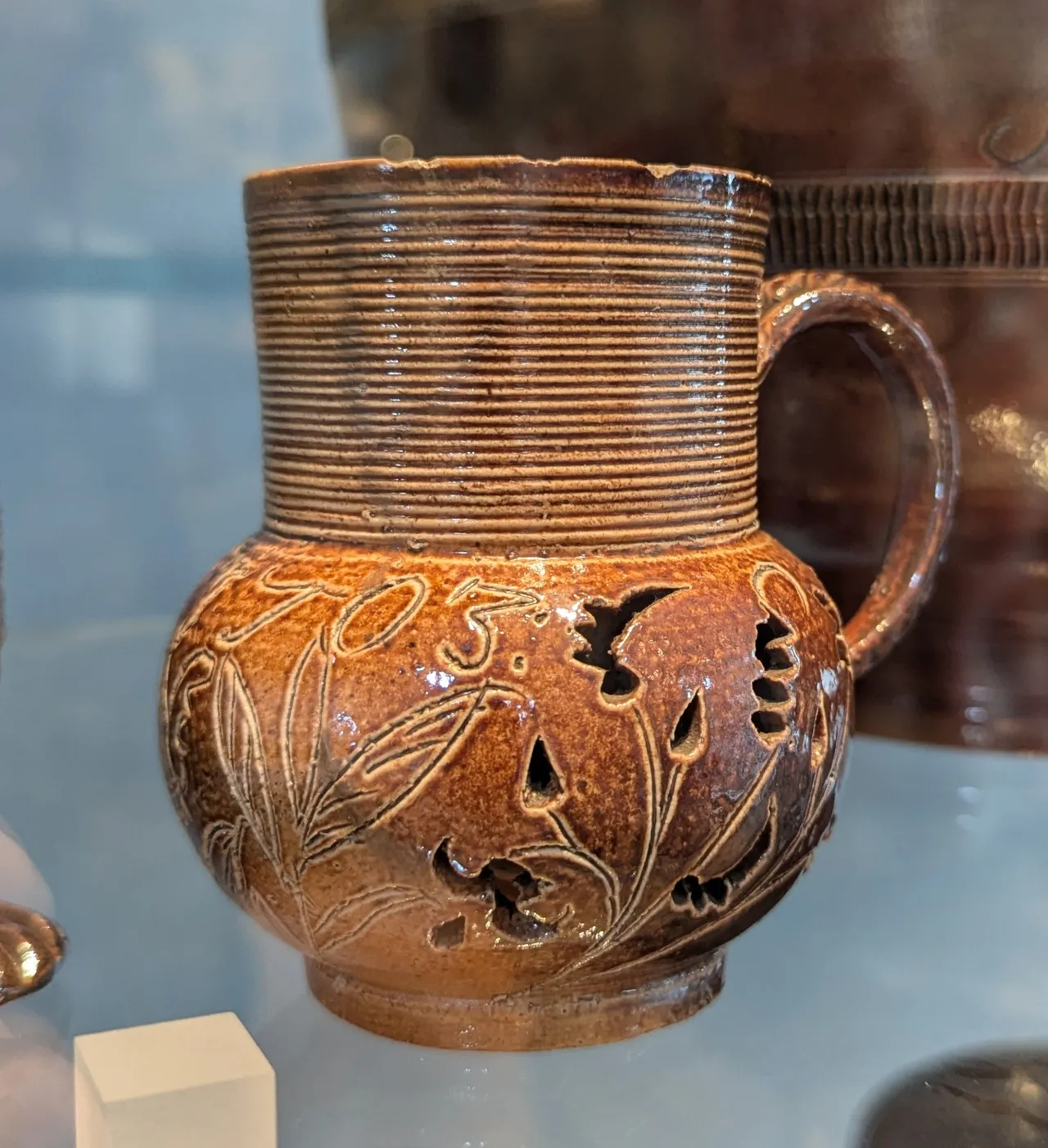 Stoneware mug, made 1703 (at least that’s what the date on it says). It is double-walled, the liquid-containing part is a straight-sided cylinder, but the exterior skirt has piercing decorations. I love this idea, and have been nonstop thinking about how to throw and sculpt something like this since seeing it. Expect to see a lot of posts about this kind of thing in the near future.