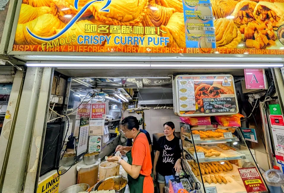 First of all, curry puffs are a great idea. Take some delicious curry and put it inside a puff pastry, what’s not to love? But also? Take a look a this super-tiny stand. There are three people here working, one guy filling and folding the puffs (couple hundred a day, note the drying / waiting racks hanging from the ceiling), plus someone in the back doing the frying, and the woman was doing counter sales. That is a lot of work, day after day, in a small space. It was also, as you can only imagine in an open-air building with a lot of fryers running, pretty warm.