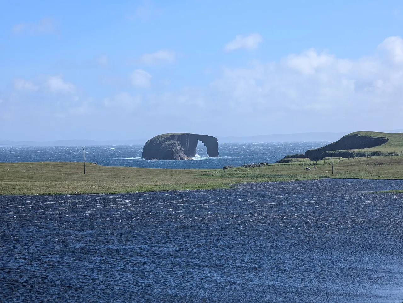 Sea stack, sea, land, loch.