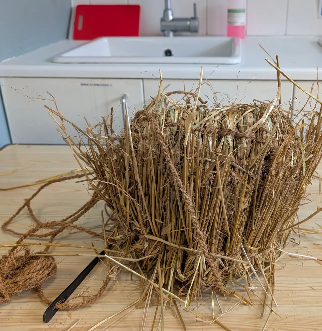 The main shaping is complete. I need to still use a backstitch technique here to sew down the folded-over ends of the straw. The basket is a little bigger than I first expected- I hit a groove and went around one more time (the twining goes in a spiral up the basket, so you can just keep going if you want, but you kind of need to stop at the right place opposite where you started or else your basket will be uneven.