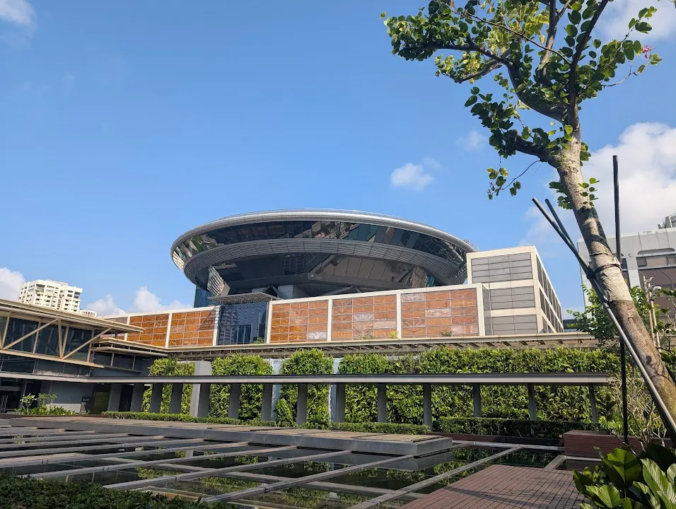 The big round flying saucer building is not a rotating restaurant. It is the home to the Singapore Supreme Court.